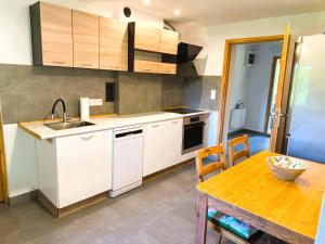 a kitchen with white cabinets and a wooden table at Agroturystyka Różanka in Nowy Tomyśl