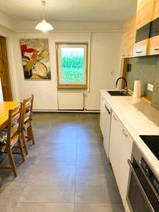 a kitchen and dining room with a table and a window at Agroturystyka Różanka in Nowy Tomyśl
