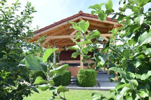 a wooden gazebo with a bench in a garden at Agroturystyka u Ani in Worpławki