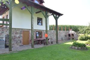 a garden with a picnic table and a stone wall at Agroturystyka u Ani in Worpławki