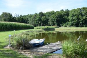 a small boat is docked at a dock on a lake at Agroturystyka u Ani in Worpławki +26 photos