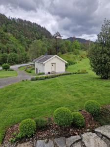 a small white house in the middle of a yard at Ropeid Fjordferie in Ropeid