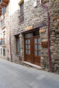 a stone building with a wooden door on a street at Casa Loma Lola in Molinaseca