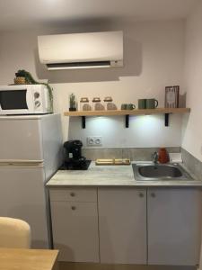 a small kitchen with a sink and a microwave at À Casarella di Lisa in Vescovato +1 photo