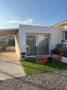 a house with a lawn with chairs and a table at À Casarella di Lisa in Vescovato
