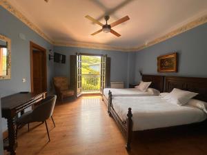 a bedroom with two beds and a ceiling fan at El Mirador de Deva in Deva