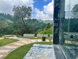 a view from a glass door of a garden at Sky Frame cottage in Demodera