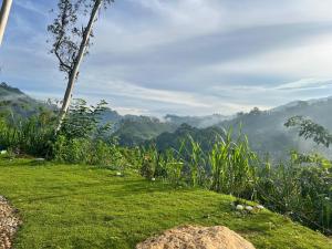 a grassy hill with a view of the mountains at Sky Frame cottage in Demodera