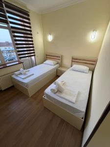 two beds in a room with a window at Oscar Hotel Guba in Quba +1 photo
