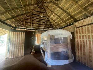 a bedroom with a bed in a straw hut at Nature Kingdom Sri Lanka in Hambegamuwa