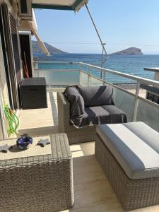 a balcony with wicker chairs and a couch on a boat at Nenas house in Porto Rafti