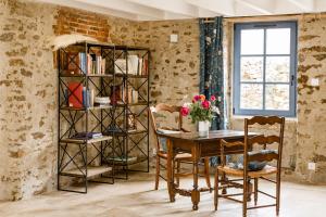 a dining room with a table and a book shelf at La borderie de Beauregard in Treize-Vents