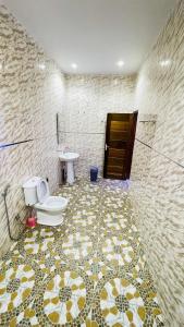 a bathroom with a toilet and a sink at Residence ADN Walo in Richard Toll +14 photos