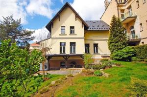 a large white house with a yard at Apartmán Palza Jablonec in Jablonec nad Nisou