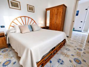 a bedroom with a large bed and a wooden chair at Maridea - La Marina in Ponza