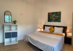 a bedroom with a bed and a painting on the wall at Ciao Tavira in Tavira