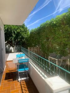 a patio with blue chairs and a table on a balcony at Ciao Tavira in Tavira