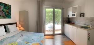 a bedroom with a bed and a kitchen with a balcony at Ciao Tavira in Tavira +34 photos