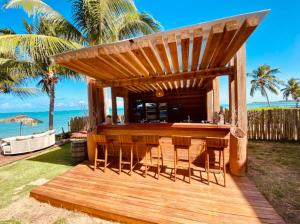 a wooden bar with a wooden table and chairs at Pousada Marceneiro in São Miguel dos Milagres