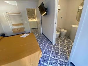 a bathroom with a toilet and a tub and a sink at Cinquestelle Albergo del centro storico in Palinuro