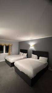 a bedroom with two beds with white sheets at Edinburgh West Residences in Edinburgh