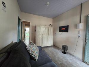 a living room with a couch and a tv on the wall at MAEVE Albergue in Goiás