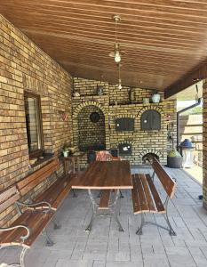 a patio with a wooden table and two benches at Borowy Zielnik 