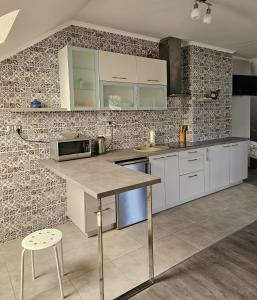 a kitchen with white cabinets and a tile wall at Borowy Zielnik 