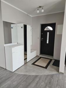 a room with a black door and white cabinets and a floor at Borowy Zielnik 