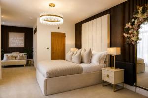 a bedroom with a large white bed and a chandelier at Cedar House at The Old Fire Station in Canterbury