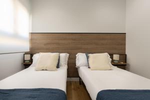 two beds sitting next to each other in a room at The Rooftop Apartments in Basauri