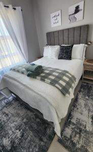 a bedroom with a large bed with a blanket and pillows at Ocean Whisper Strandfontein in Strandfontein