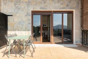 a table and chairs on a patio with sliding glass doors at The Rooftop Apartments in Basauri