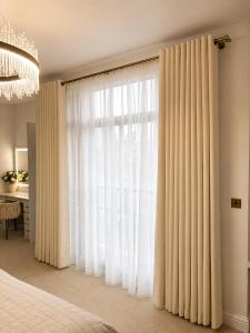 a bedroom with a large window with white curtains at Cedar House at The Old Fire Station in Canterbury +9 photos