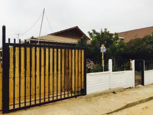 una puerta negra y amarilla delante de una casa en Bello Horizonte, en El Quisco