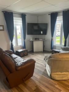 a living room with a couch and a flat screen tv at Condo DidiPier in La Tuque