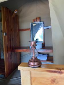 a glass jar on a wooden table with a mirror at Oloibormut in Sekenani +14 photos