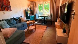 a living room with a blue couch and a table at Ferienhaus Elsterblick in Bad Elster