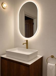 a bathroom with a white sink and a mirror at Cedar House at The Old Fire Station in Canterbury
