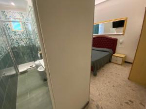 a bathroom with a shower and a bedroom with a bed at Cinquestelle Albergo del centro storico in Palinuro