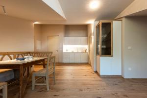 a kitchen with a table and a dining room at Essa Rooms NEW in Caldaro +13 photos