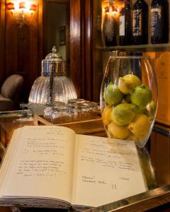 an open book on a table with a vase of fruit at Resort Dei Limoni Tower Inn in Lucca