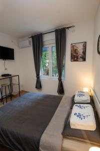 a bedroom with a large bed and a window at Naissus Apartments in Niš