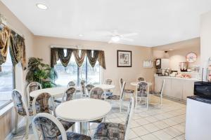 a dining room with tables and chairs and a kitchen at Howard Johnson by Wyndham Modesto Ceres in Ceres