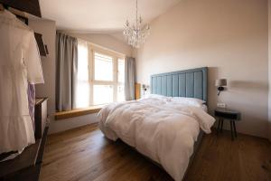 a bedroom with a large bed and a chandelier at Essa Rooms NEW in Caldaro