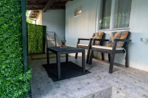 a patio with a table and chairs on a porch at Naissus Apartments in Niš