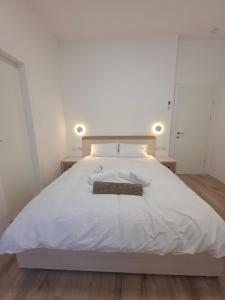 a bedroom with a white bed with two towels on it at Koresh 10 - Emilia suite in Jerusalem