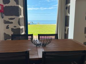 a wooden table with two chairs and an umbrella on top at Blue Whale Appartment in Horta