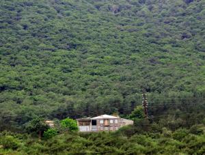 a house on a hill in front of a mountain at Yeghevnut Hotel in Goris