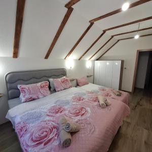 a bedroom with a bed with pink roses on it at Planinska kuća Aurahill-Blidinje in Blidinje